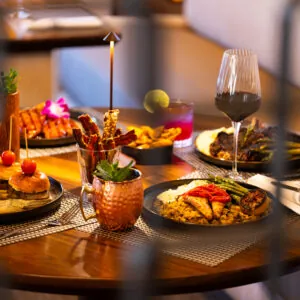 Dining table full of colorful dishes and wine glasses.