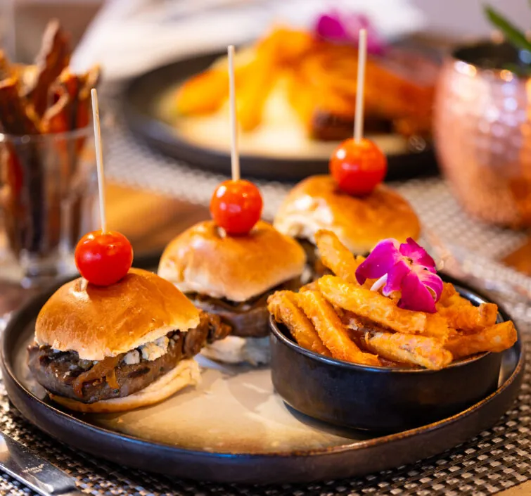 Mini burgers with fries and cherry tomatoes.