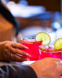 Two people holding cocktails.