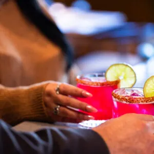 Two people holding cocktails.