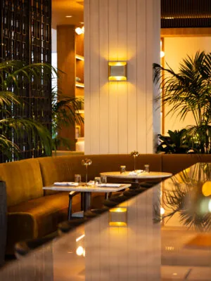 Coyz restaurant seating with brown booths, plants and wall lighting.